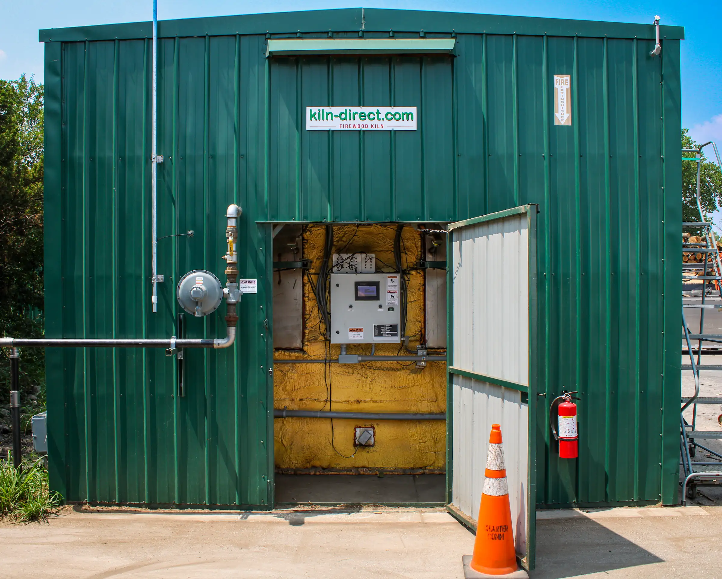 Backend view of the firewood kiln control panel, burners, and electrical components at Best Burn Firewood