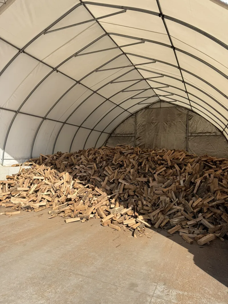 Kiln-dried firewood stored under covered shelter on concrete floor at Best Burn Firewood New Berlin Wisconsin