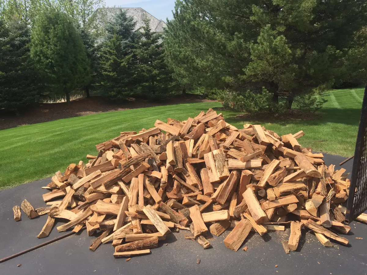 full cord of firewood dumped as a loose pile in a customer driveway in Wisconsin before stacking