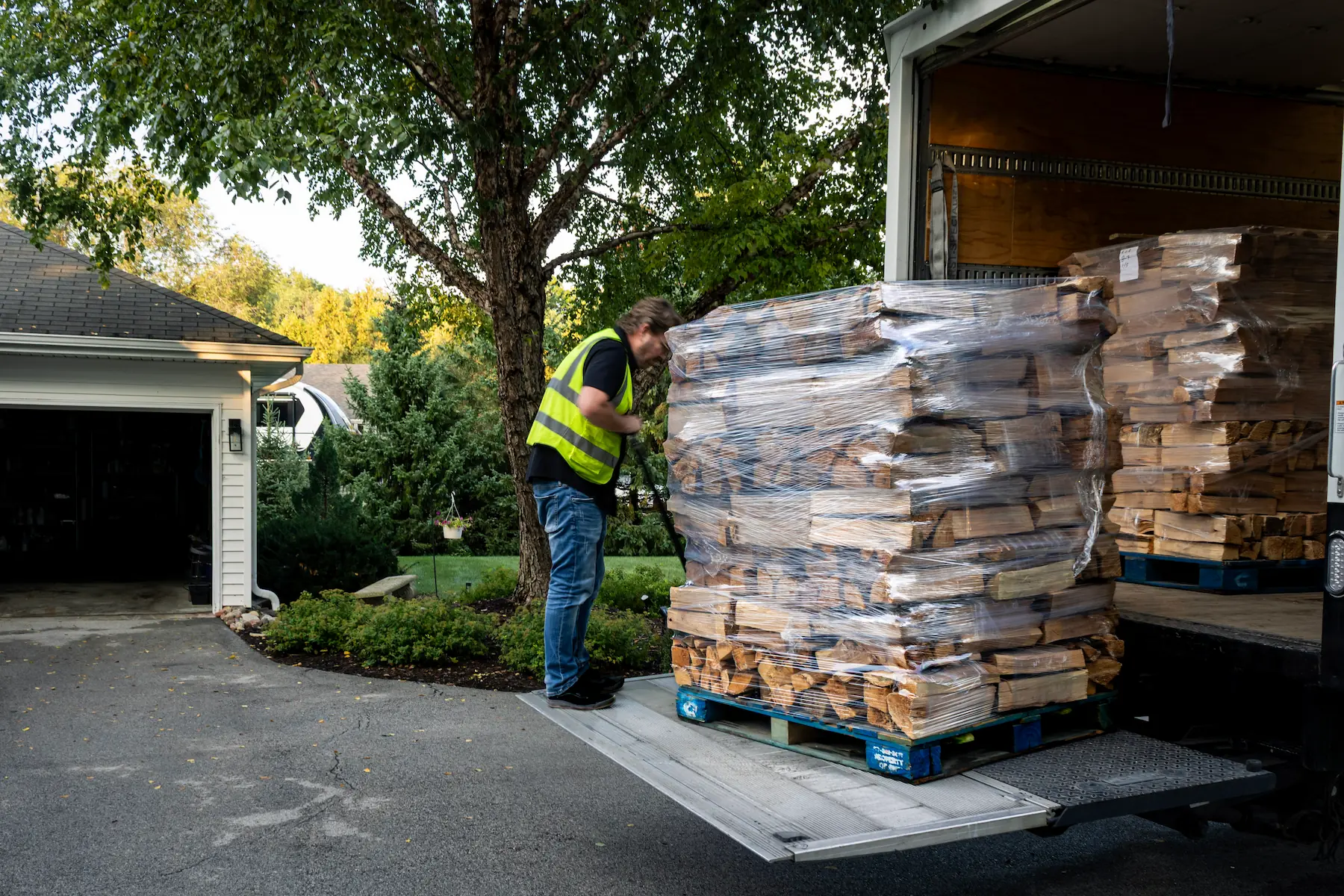 Best Burn Firewood driver lowering a pallet of firewood bundles from the truck liftgate