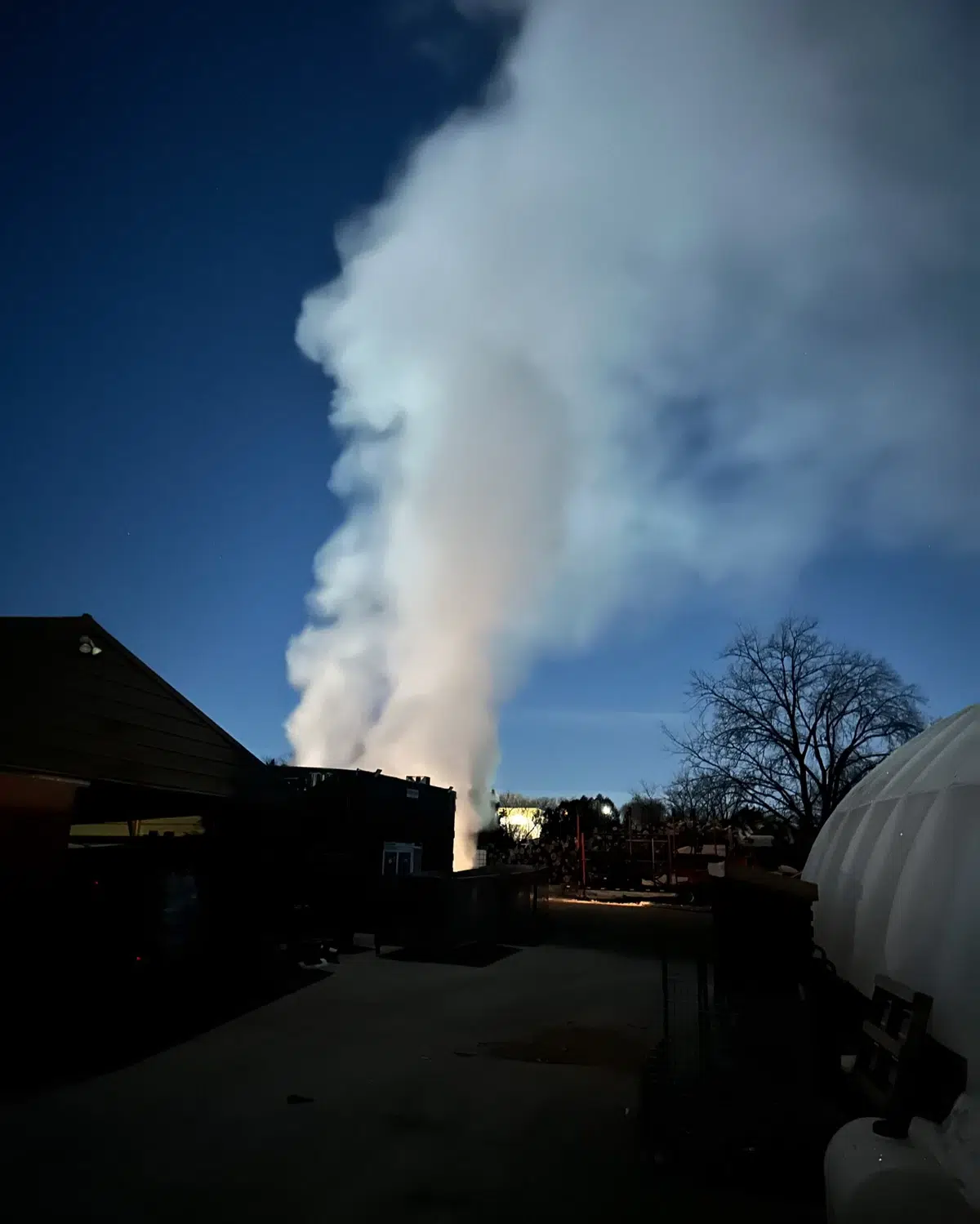 Steam rising from the firewood kiln at dusk as moisture is removed from the wood inside, Best Burn Firewood, New Berlin, Wisconsin