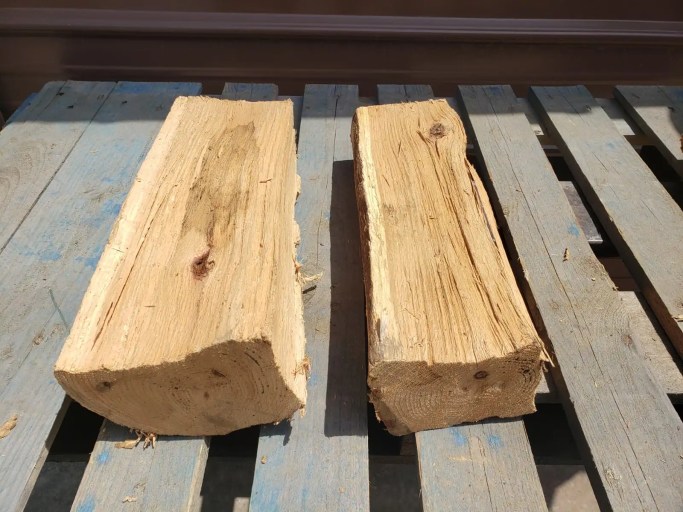 Kiln dried red oak logs showing a warmer tan color and slightly smaller size after drying