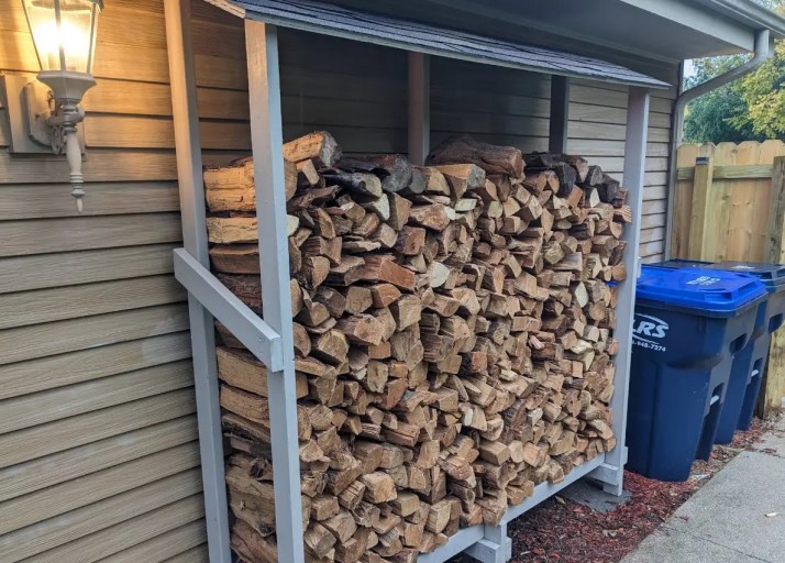 neatly stacked firewood in a covered wood shed showing straight rows and open sides for airflow